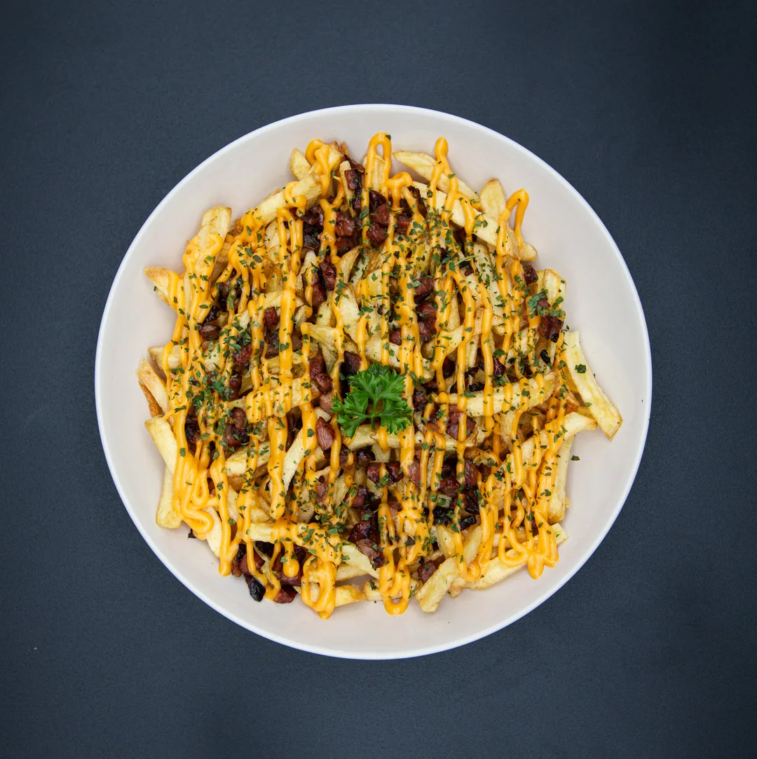 Batata frita coberta com cheddar cremoso, bacon e salsa picada