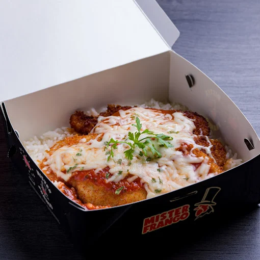 Bife à parmegiana com arroz, servido em caixa de take-away preta com o logótipo do Mister Frango